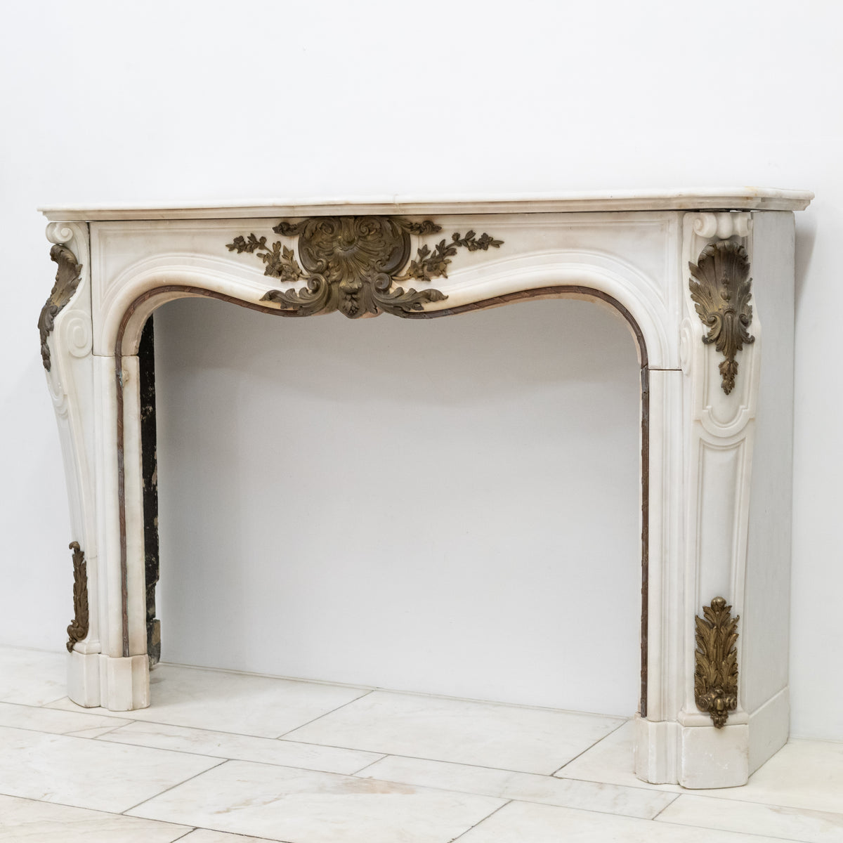 Antique French Louis XV Style Statuary Marble Fireplace with Brass Mounts | The Architectural Forum